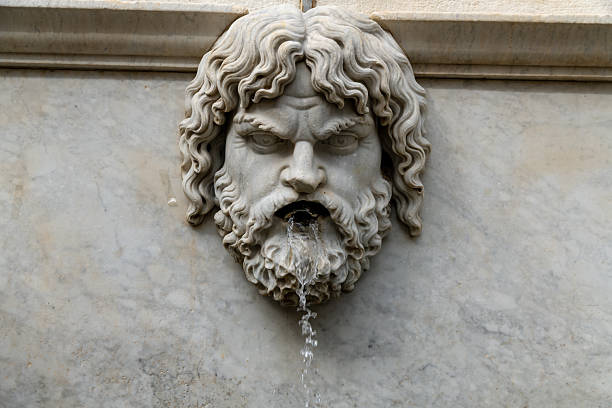 Vatican City, Vatican City State - October 11, 2007: The artist and architect Gian Lorenzo Bernini designed St. Peter's Square and redesigned the Maderno Fountain (1612 - 1614). Photo shows the Bernini Fountain was completed in 1677, The design is based on the modified but earlier Maderno Fountain on the opposite side of the Square. Tourists and pilgrims are seen on the Square. Shot in the afternoon sunlight; vertical format.