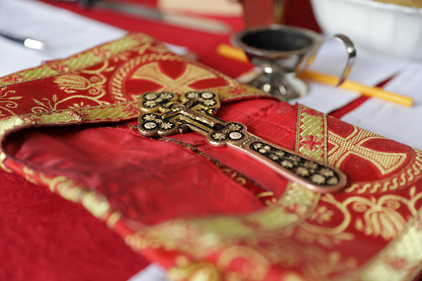Ornate Orthodox Cross Resting On Rich Red Liturgical Fabric With Gold Embroidery, Representing Christian Faith, Religion, Worship, Tradition, And Sacred Church Ceremony.