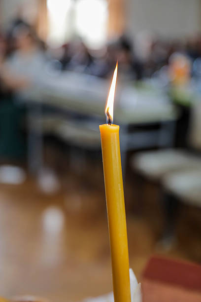Lit Yellow Candle With Burning Flame In Indoor Setting, Creating A Calm And Spiritual Atmosphere With Soft Focus Background, Representing Faith, Remembrance, Prayer, And Hope Concepts.