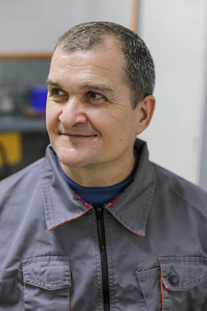 Front View Portrait of a Middle Aged Man Wearing a Work Jacket, Looking Directly at the Camera With a Neutral Expression, Representing Labor, Industry, Experience, and Real People Concepts.