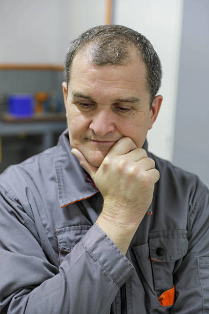 Front View Portrait of a Middle Aged Man Wearing a Work Jacket, Looking Directly at the Camera With a Neutral Expression, Representing Labor, Industry, Experience, and Real People Concepts.