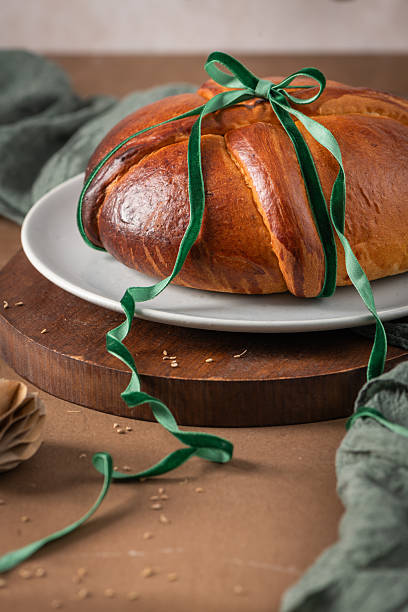Portuguese traditional Easter cake Folar without eggs on easter table with a green velvet ribbon tied in a bow