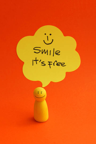 A generic three dimensional yellow laughing face with tears of joy emoji with legs and arms looking towards the viewer with mouth open. The character is standing on a plain background with side lighting creating soft shadows. With plenty of copy space.