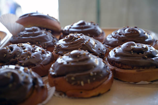 Chocolate-frosted donuts arranged on display in a bakery in El Rosario, Sinaloa, Mexico. The image reflects local food offerings and small-business baking environments. Suitable for bakery marketing, desserts, comfort food, and culinary lifestyle themes.