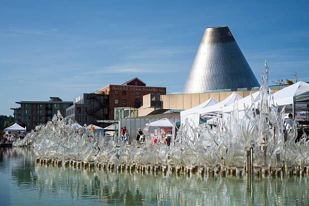 Tacoma, USA - August 9, 2025. Glass sculptures with tourists walking behind at Museum of Glass in downtown Tacoma, Washington State, USA
