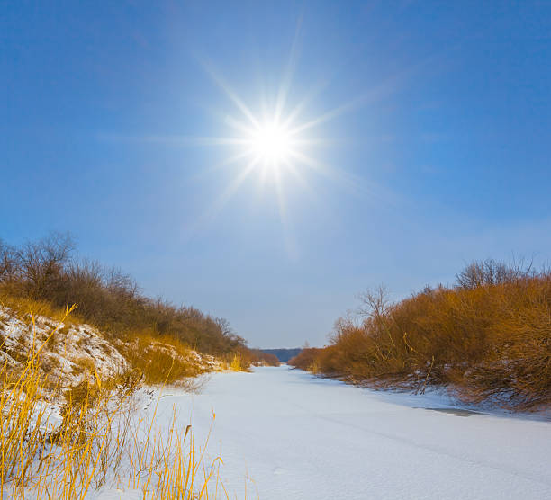 frozen winter river with forest on coast at the bright sunny day