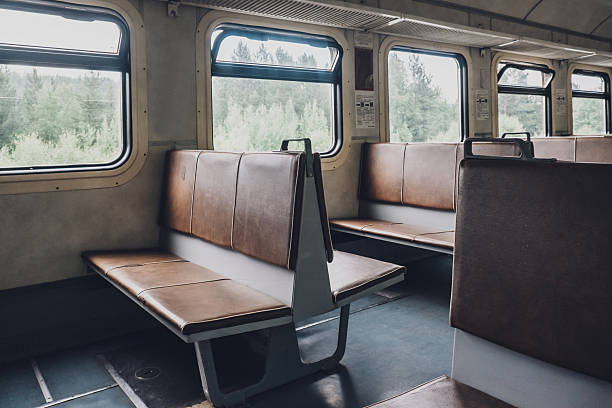 train interior with empty benches and green view outside window on travel day. closeup.