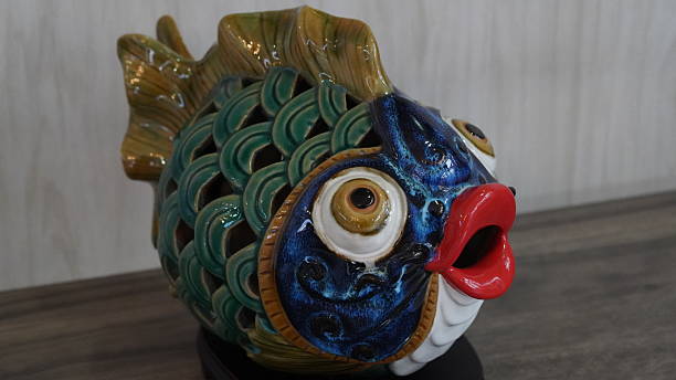 This whimsical ceramic fish sculpture boasts vibrant colors and intricate details A perfect decor piece for any fish lover or art enthusiast Add a touch of fun to your home or office