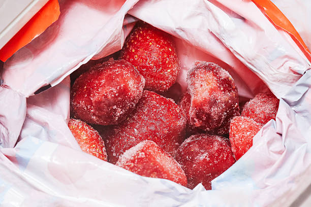 istock Frozen strawberries inside plastic bag. Fresh red fruit covered with ice crystals. Natural berries preserved by freezing. 2258981169