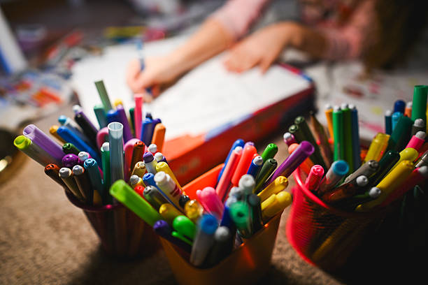 Child's hands drawing with markers, focusing on art and education