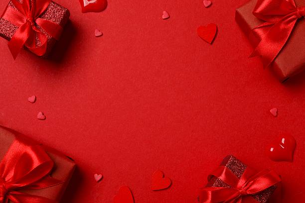 istock Festive postcard with beautiful gift boxes with red hearts on color background 2259019075