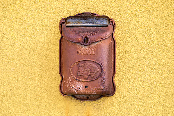 Forged metal mailbox on a yellow wall outside
