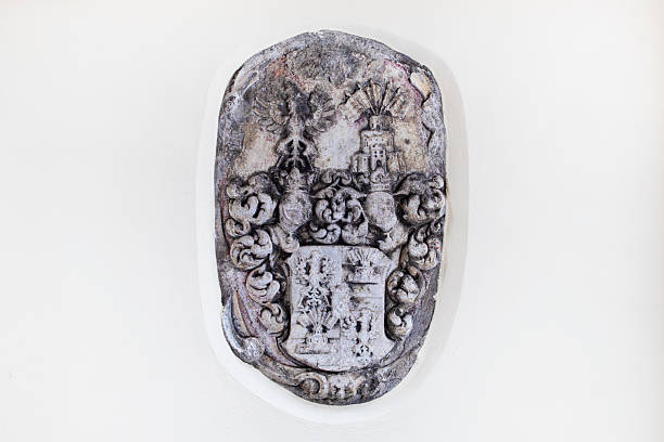 stone relief coat of arms with shield, crown and floral elements on the sides