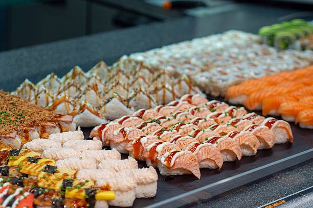 Assorted sushi rolls on a black tray, beautifully presented and ready to eat