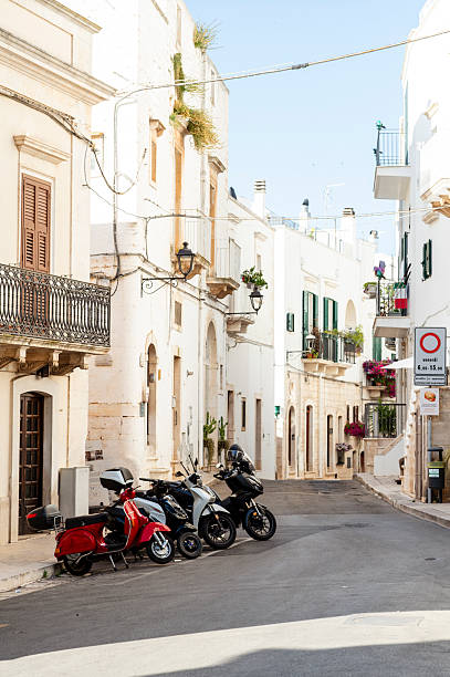 Alberobello, Italy - June 25, 2025: View of one of the many beautiful little alleys with beautifully designed balconies and houses in Alberobello, a town known especially among tourists for its numerous trulli houses.