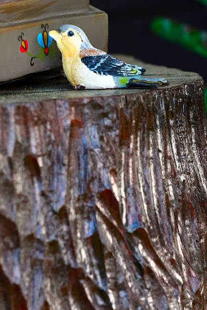 Colorful folkloric style Bird figurine on Rustic Wood Stump