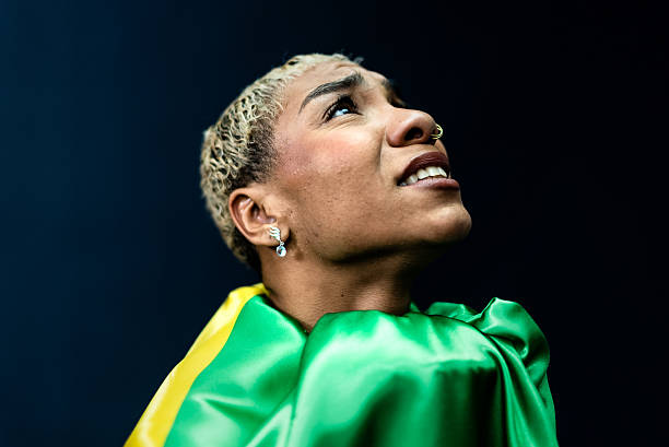 Brazilian family celebrating and watching a football game together. Parents and their daughter sitting on the couch, smiling with excitement. Happy black family of soccer fans.