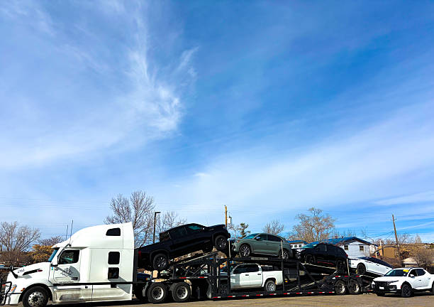 Santa Fe, NM - January 22, 2026: A big rig car transporter unloading a car in the De Vargas Shopping Center parking lot.