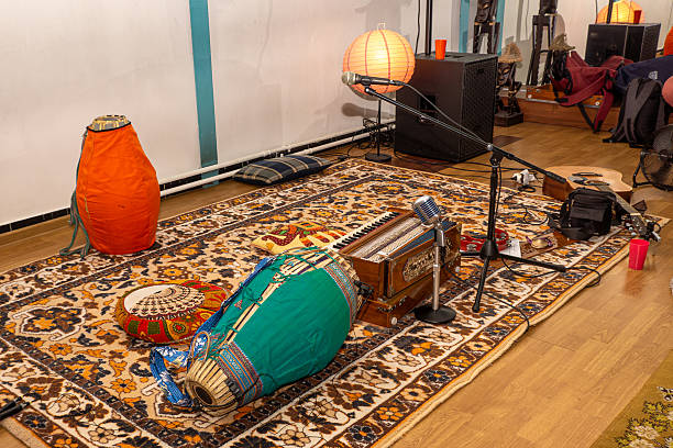 Everythings laid out: big drum on rug, wooden box with keys, retro mic, soft cushions - perfect spot to sit, relax, and join the sacred sounds with selective focus