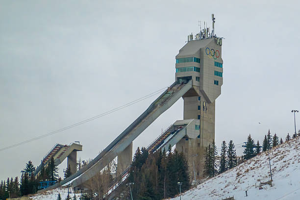Calgary, Alberta, Canada. Feb 1, 2026. The Olympic ski jump tower at Canada Olympic Park under an overcast winter sky.
