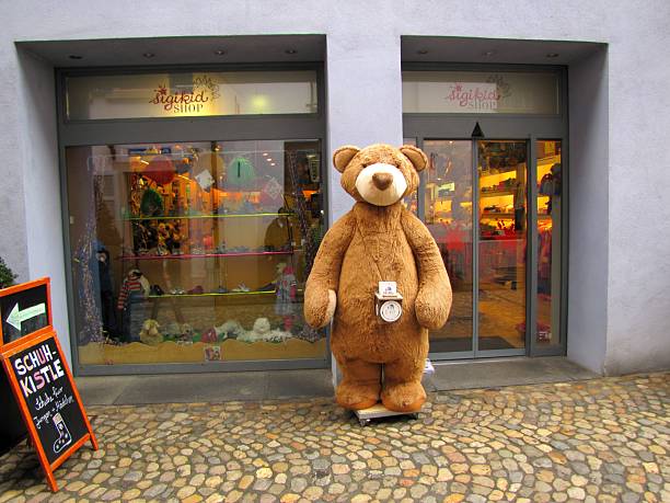 Street view of Sigikid, a German family-owned toy store founded in 1856, alongside Schuh-Kistle in Freiburg, featuring a giant plush bear in front, attracting visitors and photo opportunities, DE, 27 Feb. 2011