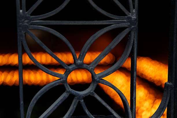Detailed wrought iron railing lines a grey staircase showcasing vintage craftsmanship in a well-lit interior.