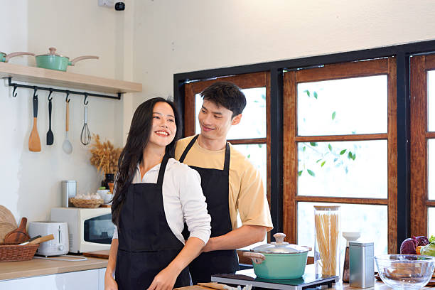 istock man helps his Girlfriend tie her apron at the back while cozy preparing for breakfast in the kitchen at home. Cooking and breakfast in the morning at home 2259085384