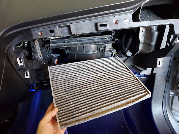 Hand Holding a Dirty Cabin Filter from a 2010s Car. High quality photo
