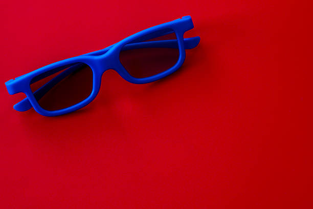 Bright blue glasses with dark lenses lie on a rich red background, creating a powerful color contrast. This minimalist accessory composition emphasizes modern style and bold design, making it perfect for conceptual visual solutions