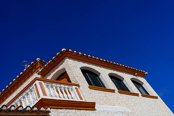 Sunlit Mediterranean-style architecture with arched windows and tiled roof stands out sharply.