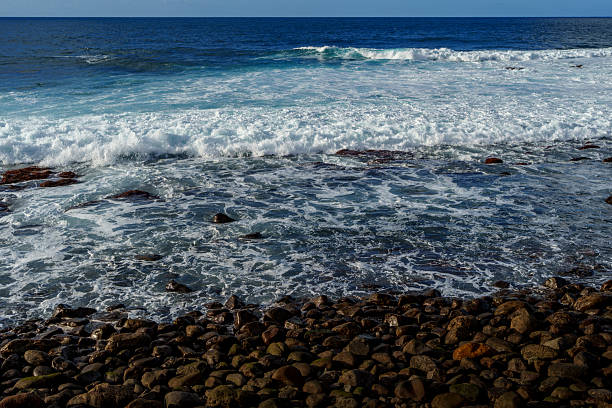 Man walking in the Atlantic Ocean at Playa de las Americas which is a popular tourist location on the south coast of the the Spanish Canary Island Tenerife.