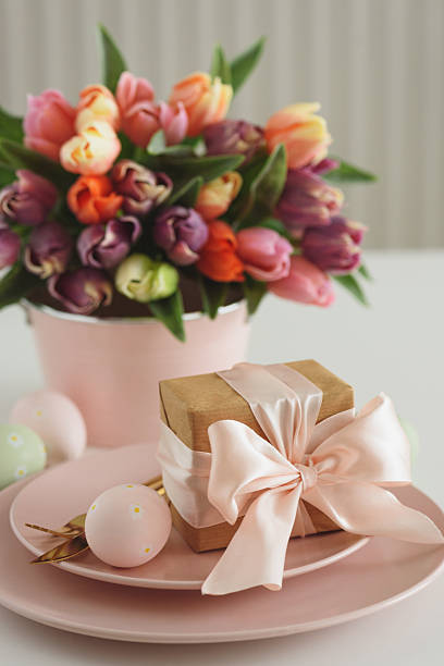 Easter Table Setting with Gift Box, Decorated Eggs and Tulips. Festive Spring Lifestyle