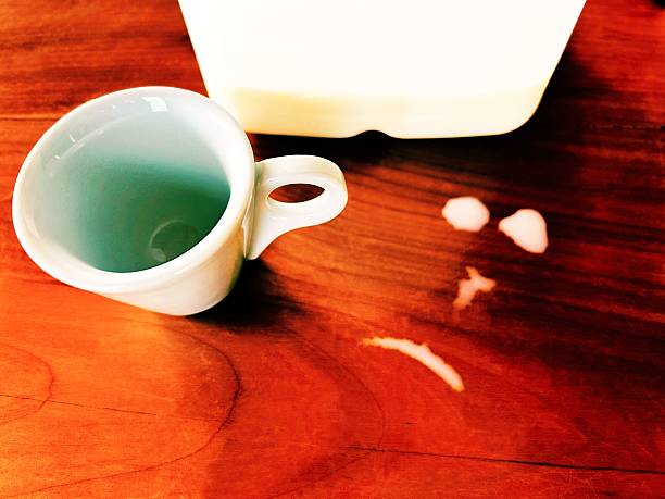 Empty glass and jar with some milk isolated on blue colored background. Milk is pouring into glass.