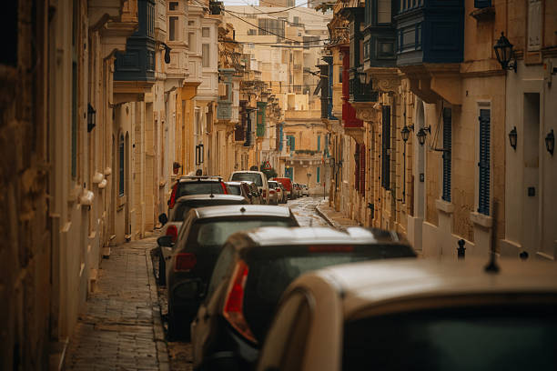 Authentic street scene in Sliema, Malta, showcasing traditional Maltese architecture and narrow sidewalks.