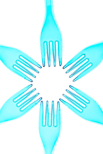 Green turquoise colored plastic cutlery against white background in pastel color