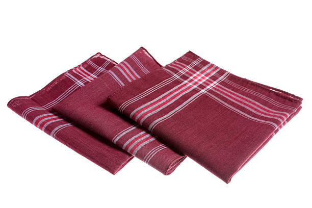 Three napkins folded over a wood table.