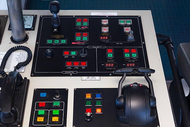 A control panel for a sea ship with various buttons, levers and switches.