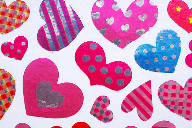 Assorted colorful heart stickers with plaid, striped, and vibrant patterns on white background