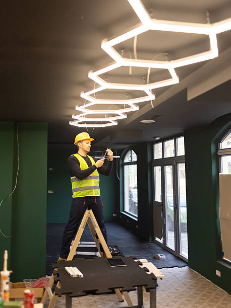 electrician installing modern hexagon led lighting system stock photo