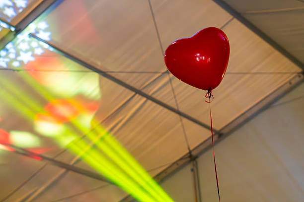 Red glossy helium balloons with silver ribbons floating on white background banner