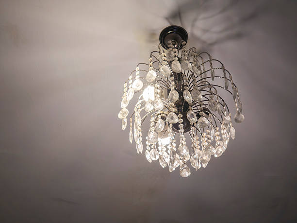 Retro Crystal chandelier hanging from a ceiling casting light and shadows, creating a luxurious ambiance and providing interior decoration in a living space