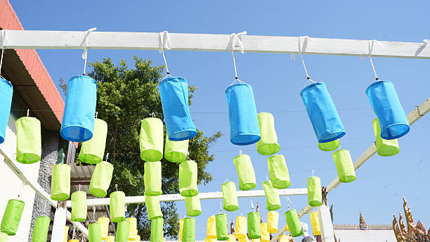 Colorful lanterns hang from white structure against clear blue sky, creating vibrant and festive atmosphere