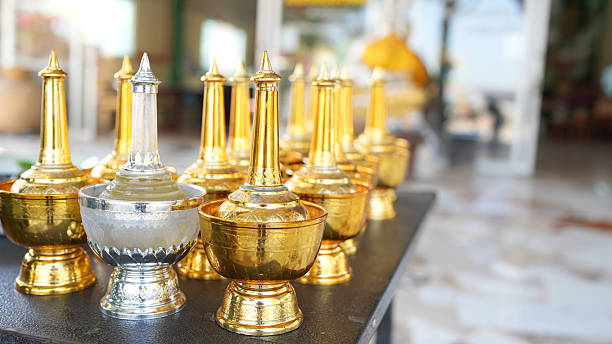 Golden and silver ceremonial containers arranged on table, reflecting light beautifully, creating elegant atmosphere