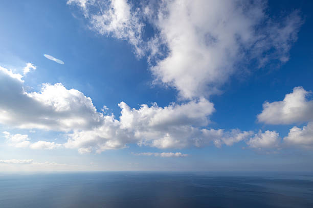 Minimalist Mediterranean seascape off the coast of Malta, featuring calm open water beneath a wide blue sky with scattered white clouds. Clean horizon and natural light create a tranquil, abstract coastal scene suitable for travel and nature concepts.
