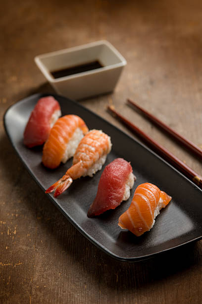 sushi sashimi with chopstick over wooden background