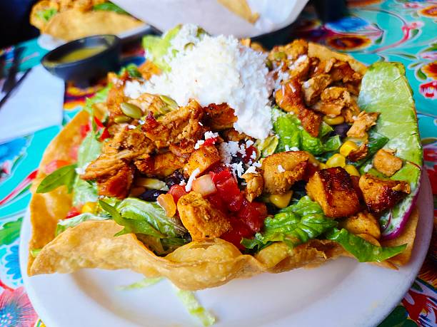 Close-up of a grilled chicken salad in a deep fried tortilla bowl.