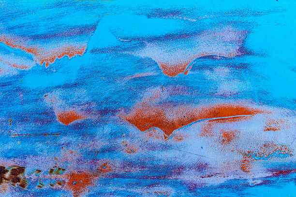 Colorful vibrant patterns in old weathered metal with red paint and scrapes from being old and left out in the elements.