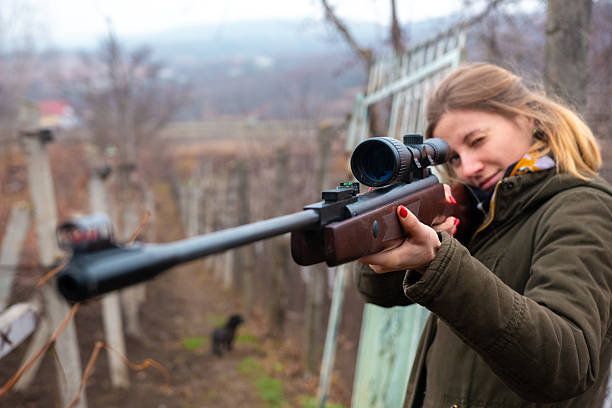Woman hunting dressed in camouflage with binoculars