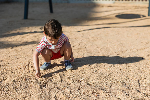 istock Young child drawing in sand at playground 2259259793