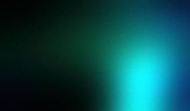 Noisy gradient blue green black grainy matte blurred abstract background with copy space. Green is the color commonly associated with nature, life, health, youth, spring, hope and envy. Colors in the cyan color range are teal, turquoise, electric blue, aquamarine, and others described as blue-green. Cyan is often associated with peace, relaxation, healthcare, dreams, and spirituality. Black commonly associated with mourning, the end, secrets, magic, force, violence, fear, evil, and elegance. Color gradient specifies a range of position-dependent colors, usually used to fill a region. The colors produced by a gradient vary continuously with position, producing smooth color transitions.